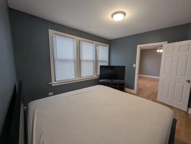 a bedroom with a bed and a large window