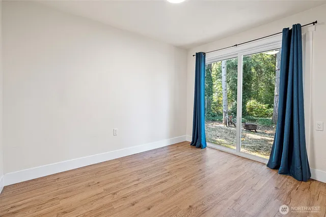 a view of a big room with wooden floor and doors