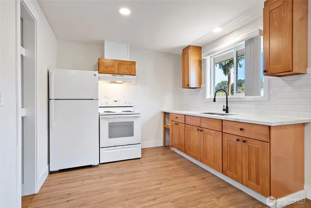 a kitchen with white cabinets and white appliances