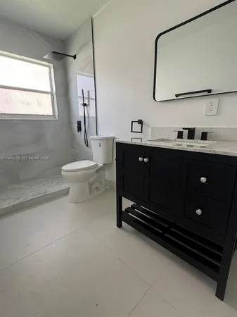 a bathroom with a toilet a sink and mirror