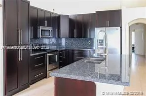 a kitchen with stainless steel appliances wooden cabinets a refrigerator and a sink