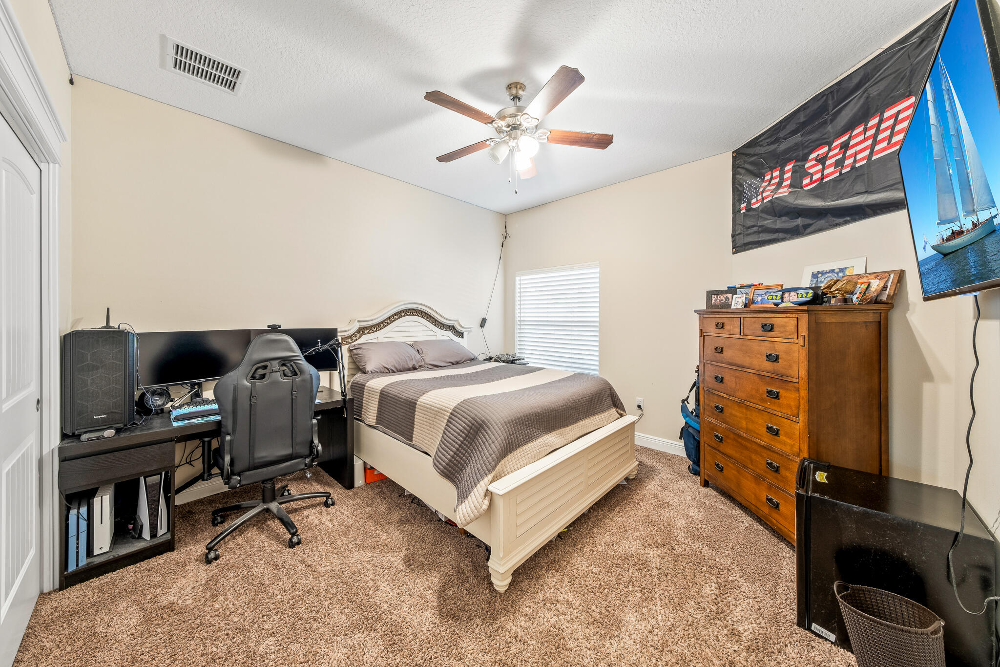 1718 Tullagee Avenue Melbourne, FL 32940 - Photo 20 of 35 a bedroom with a bed and a flat tv screen on the dresser