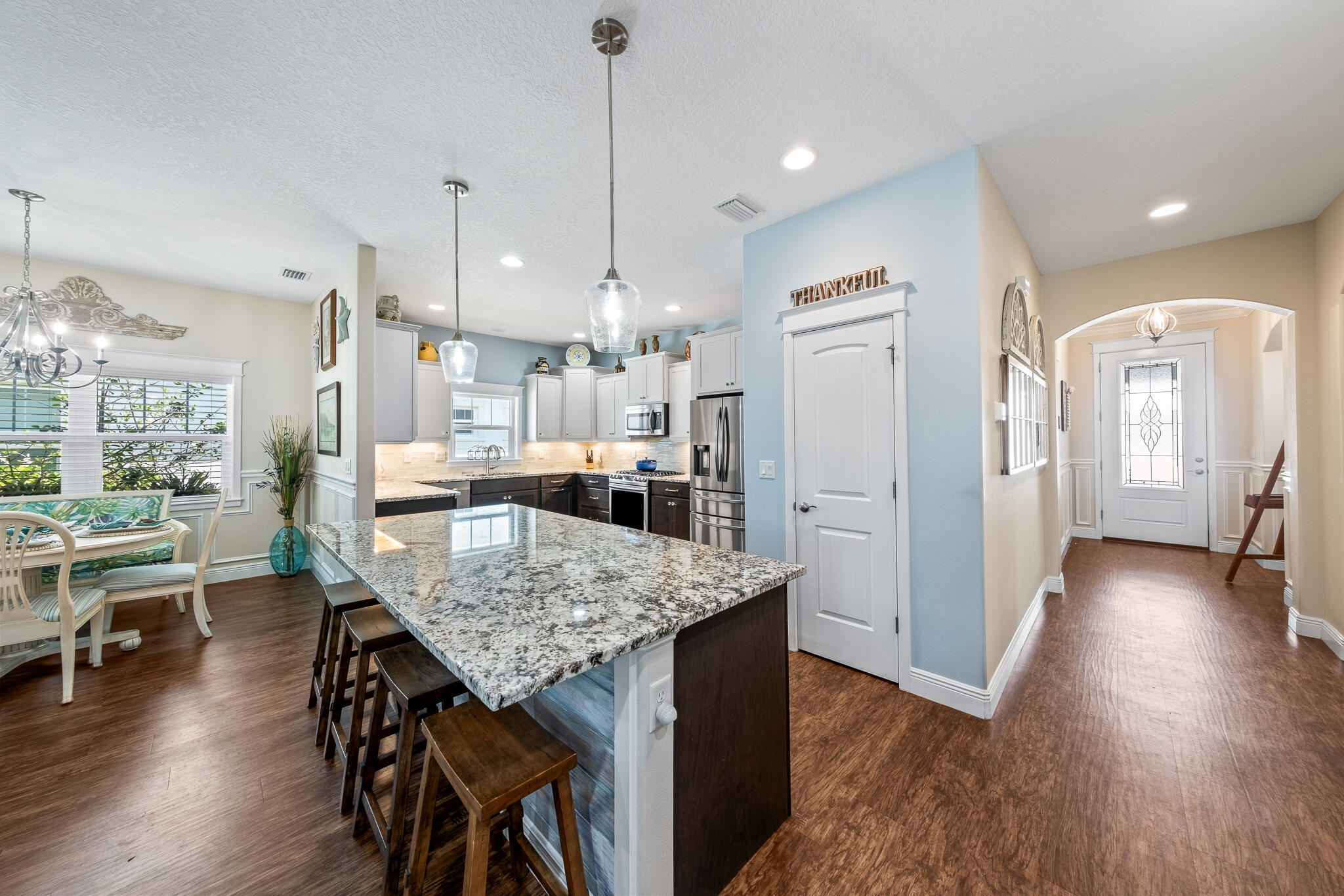 1718 Tullagee Avenue Melbourne, FL 32940 - Photo 5 of 35 a kitchen with stainless steel appliances granite countertop sink refrigerator dining table and chairs