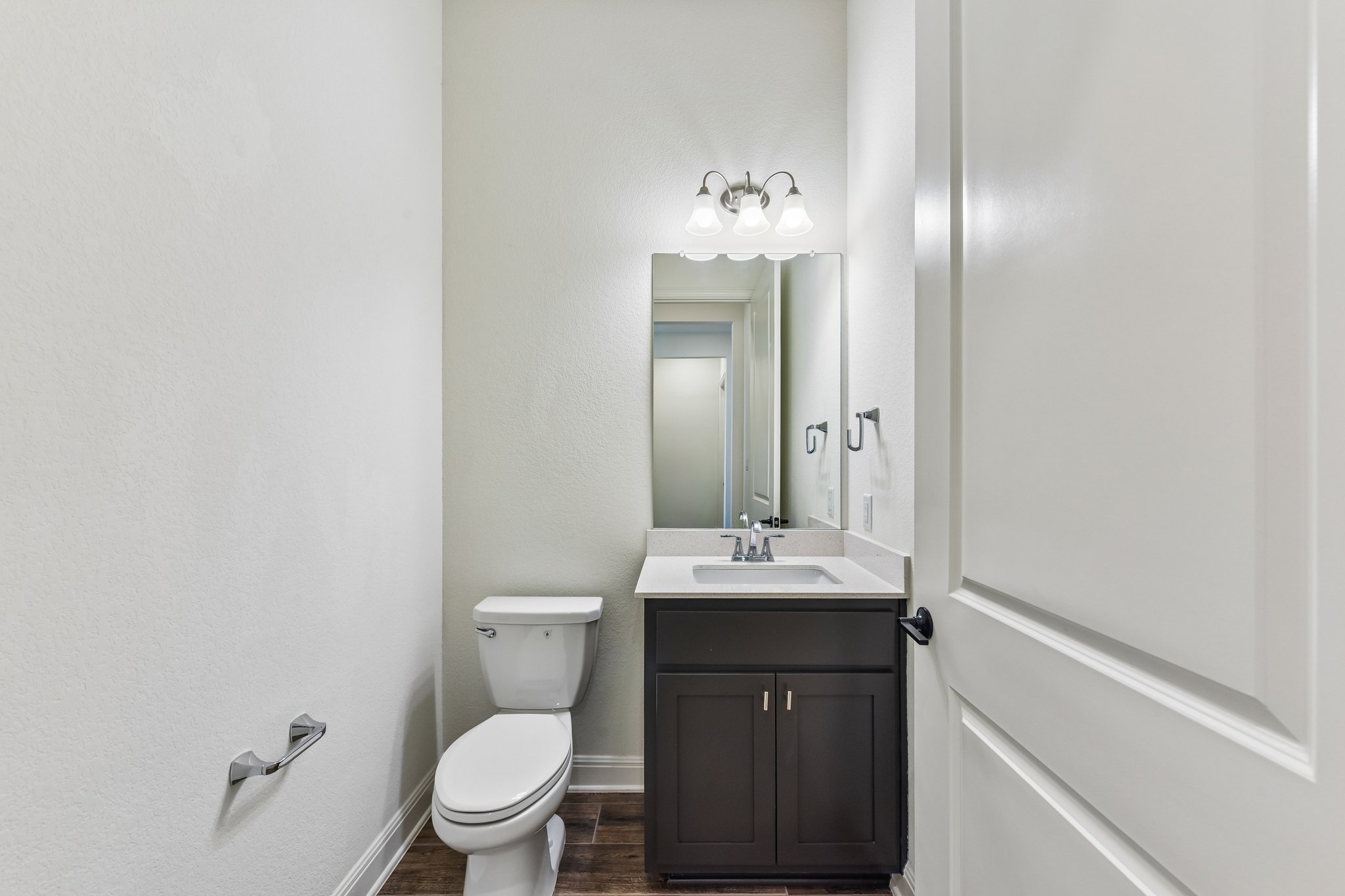19113 Freeman Circle Austin, TX 78738 - Photo 16 of 37 A well-appointed powder room featuring a modern vanity and a white commode, perfect for guests.