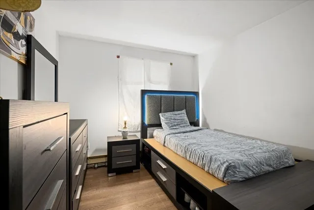 a bedroom with a bed and a refrigerator