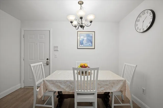 a view of a dining room with furniture a chandelier and wooden floor