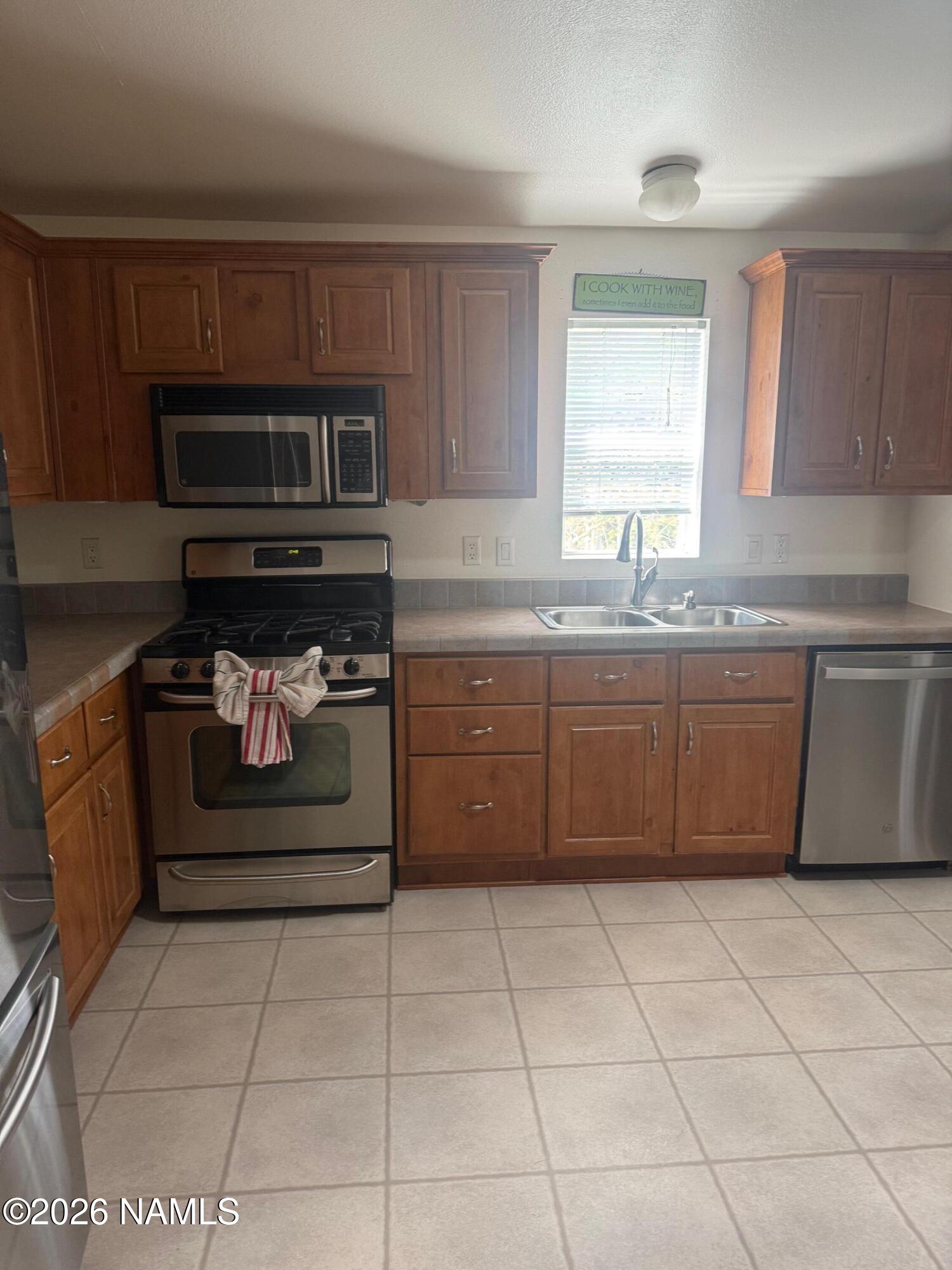 17075 Grizzly Ridge Munds Park, AZ 86017 - Photo 12 of 31 a kitchen with stainless steel appliances granite countertop a stove a sink and a microwave