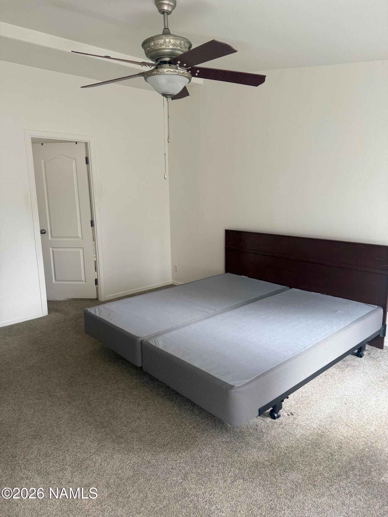 17075 Grizzly Ridge Munds Park, AZ 86017 - Photo 16 of 31 a room with a bed and a ceiling fan
