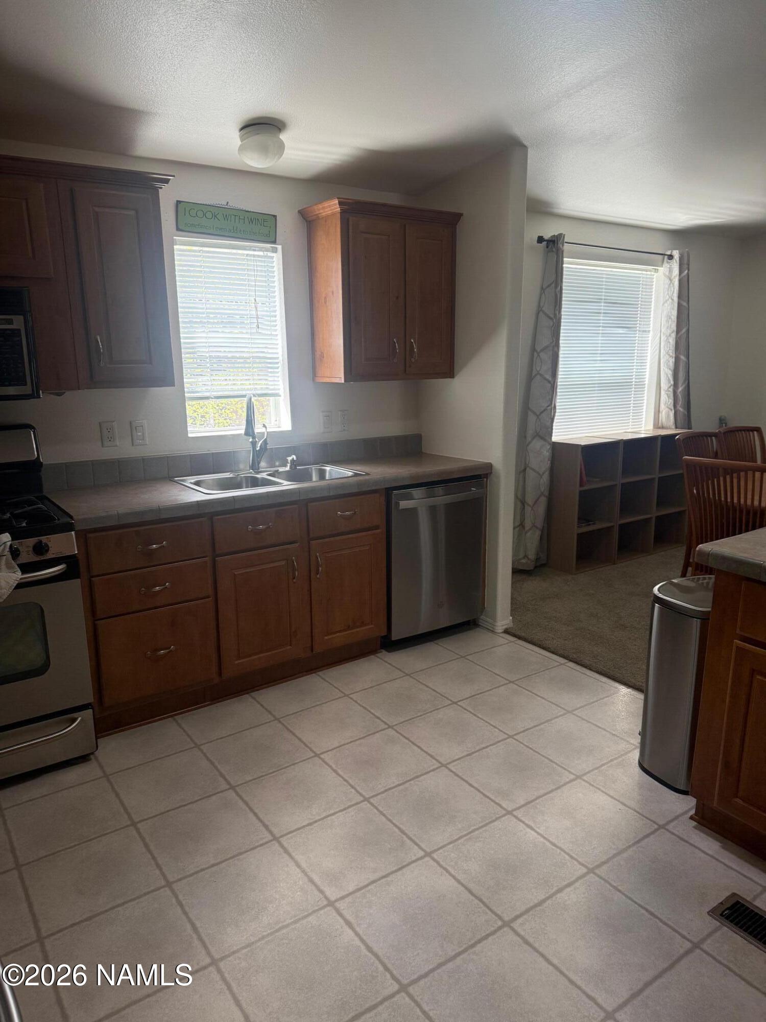 17075 Grizzly Ridge Munds Park, AZ 86017 - Photo 10 of 31 a kitchen with stainless steel appliances granite countertop a stove a sink and a microwave