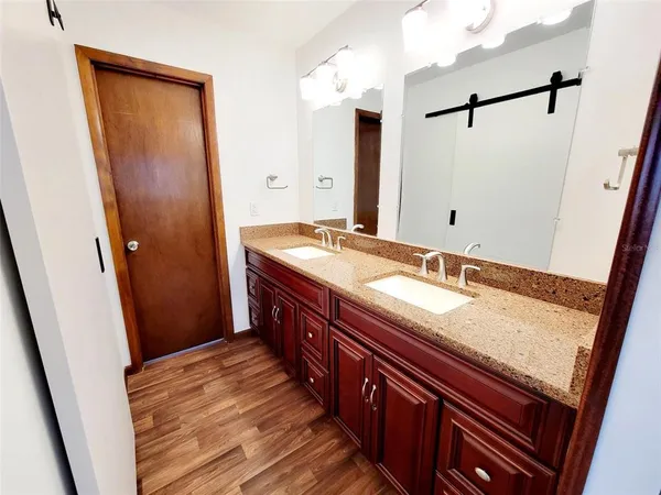 a bathroom with a granite countertop sink and a mirror