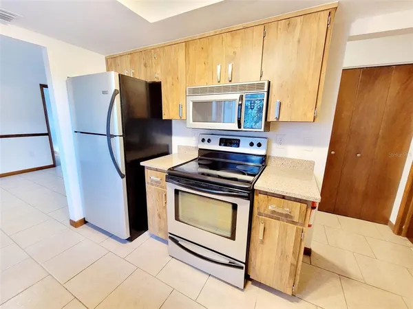 a kitchen with stainless steel appliances a stove a refrigerator and a cabinets