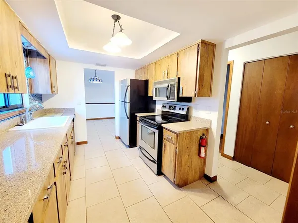 a kitchen with a sink refrigerator and microwave