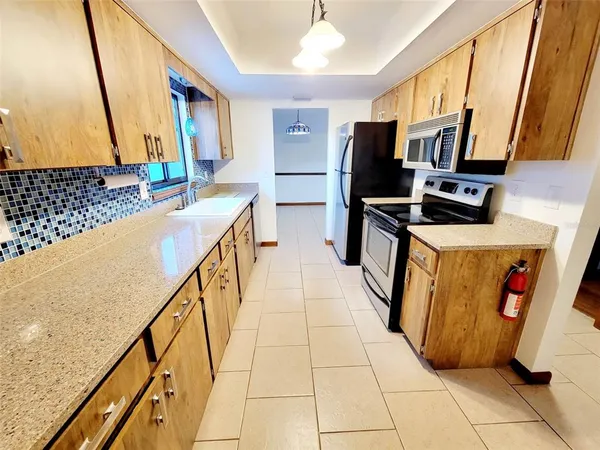 a kitchen with stainless steel appliances a sink and a refrigerator