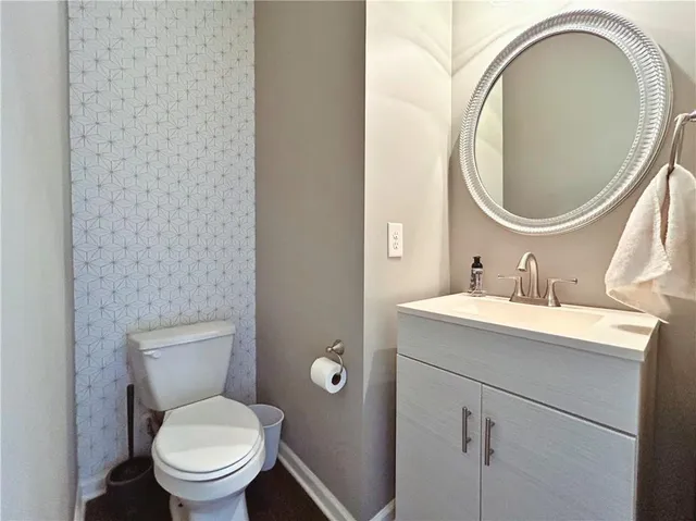 a bathroom with a granite countertop toilet a sink and a mirror