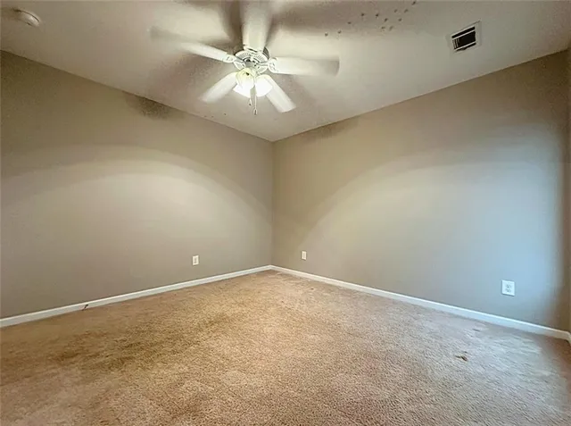 an empty room with a chandelier fan