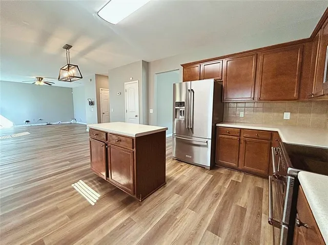 a kitchen with stainless steel appliances a refrigerator and a stove top oven