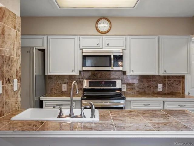 a kitchen with a table chairs a sink dishwasher and cabinets