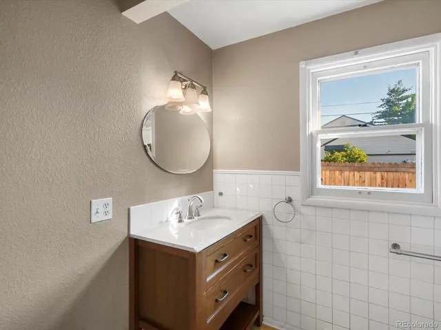 a bathroom with a granite countertop sink mirror and vanity