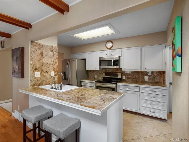 a kitchen with a stove a sink and a refrigerator