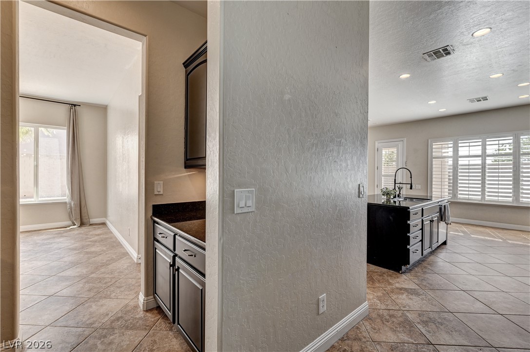 2793 Rosenhearty Drive Henderson, NV 89044 - Photo 17 of 85 This culinary space showcases a central island and a functional wet bar, ideal for entertaining.