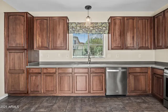 a kitchen with granite countertop a sink dishwasher stove and cabinets