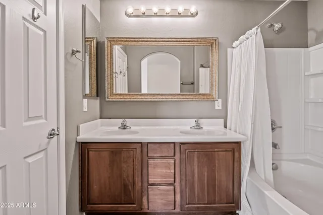 a bathroom with a granite countertop sink a mirror and a bathtub