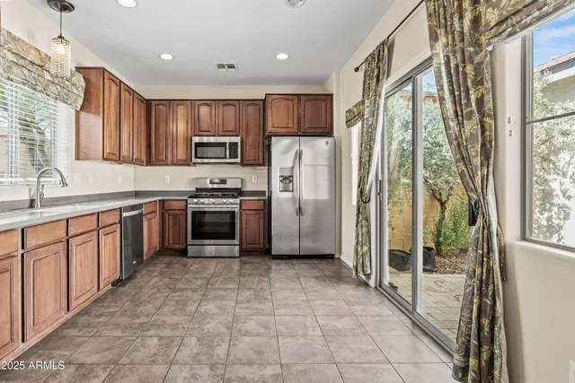 a large kitchen with stainless steel appliances granite countertop a stove a sink and a refrigerator