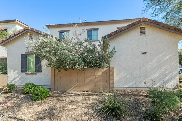 a white house with a small yard and large trees
