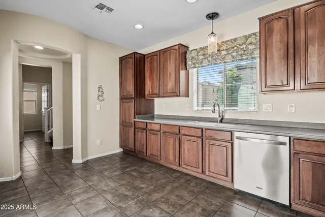a kitchen with granite countertop a sink cabinets and wooden floor