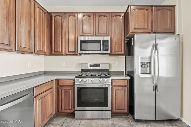a kitchen with granite countertop wooden cabinets and stainless steel appliances