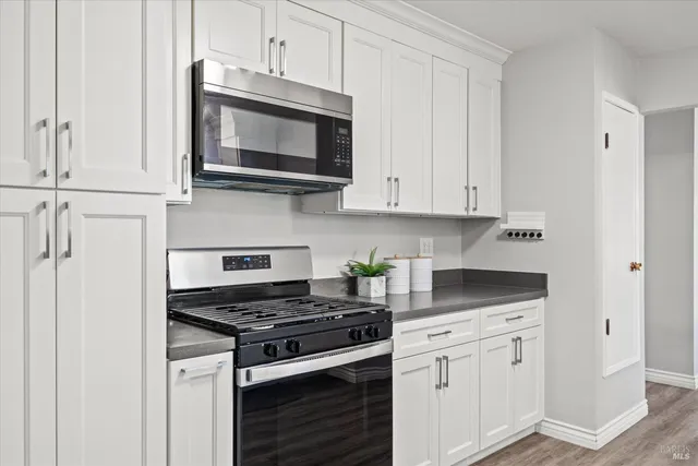 a kitchen with white cabinets and appliances
