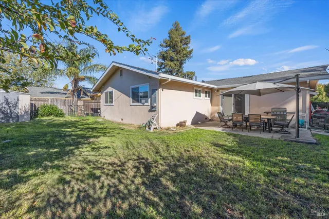 a view of a backyard with table and chairs and potted plants