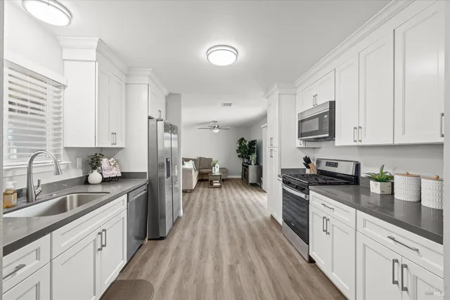 a large kitchen with stainless steel appliances granite countertop a lot of counter space and wooden floors