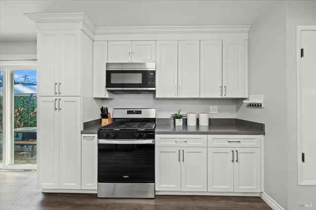 a kitchen with white cabinets and appliances