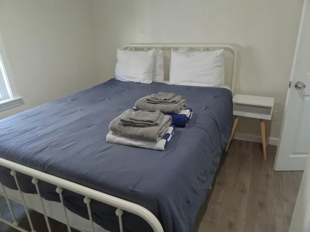 a bed sitting in a bedroom next to a window with wooden floor