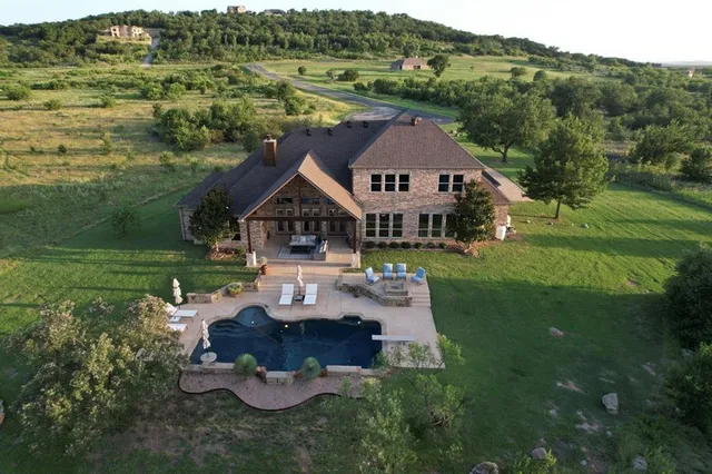 a view of a house with pool and a yard