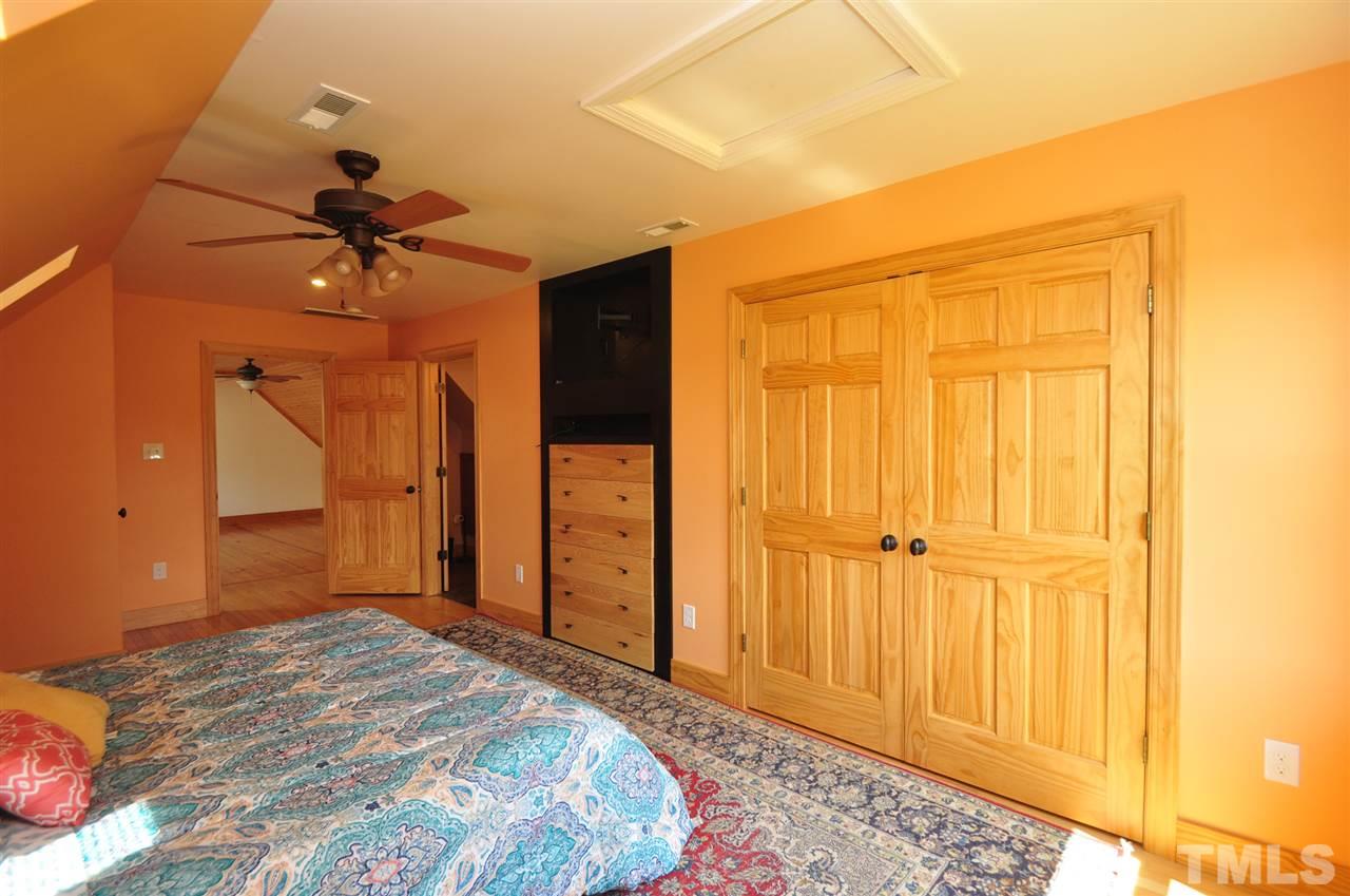 738 Castle Rock Farm Road Pittsboro, NC 27312 - Photo 19 of 25 a bedroom with a bed and a chandelier