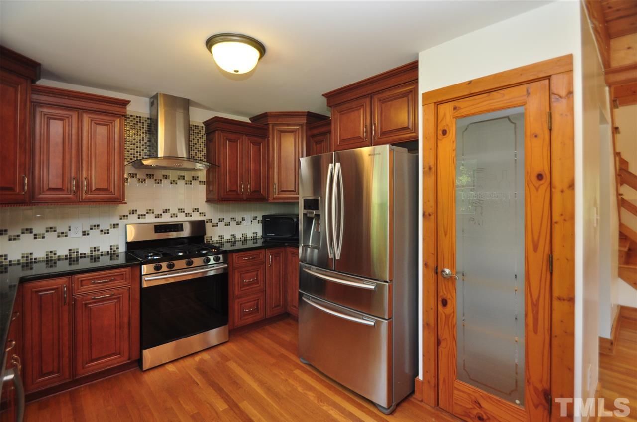 738 Castle Rock Farm Road Pittsboro, NC 27312 - Photo 7 of 25 a kitchen with granite countertop stainless steel appliances and wooden cabinets