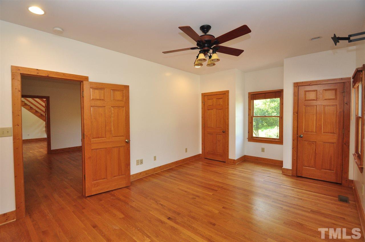 738 Castle Rock Farm Road Pittsboro, NC 27312 - Photo 10 of 25 a view of a livingroom with wooden floor and a ceiling fan