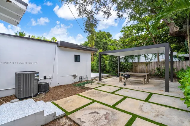 a view of backyard with outdoor seating and trees