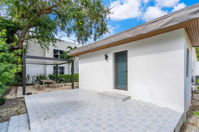 a view of a patio with table and chairs under an umbrella