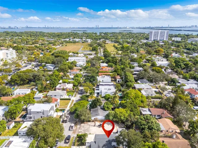 an aerial view of residential houses with outdoor space and trees