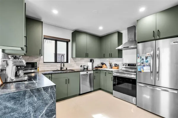 a kitchen with stainless steel appliances granite countertop a sink stove and refrigerator