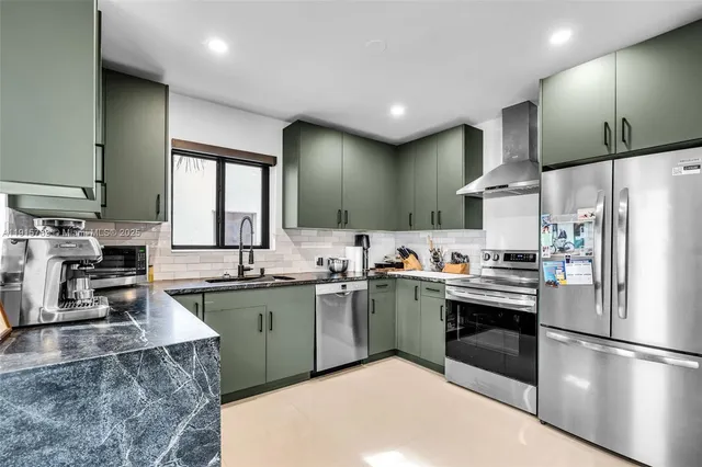 a kitchen with stainless steel appliances granite countertop a sink stove and refrigerator