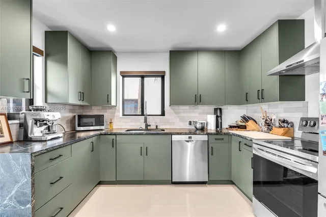 a kitchen with stainless steel appliances granite countertop a sink stove and cabinets