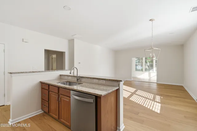 a dining hall with stainless steel appliances kitchen island granite countertop a dining table chairs and view living room