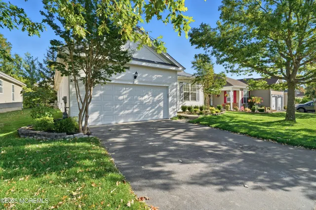 a view of a hallway with wooden floor and a living room