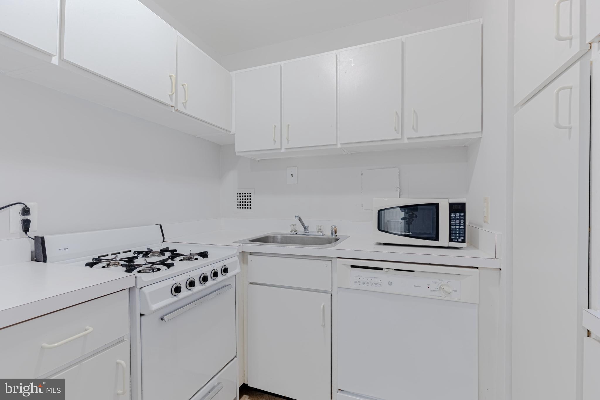 950 25th Street Northwest, Unit 327N Washington, DC 20037 - Photo 4 of 29 a kitchen with stainless steel appliances a stove a microwave and cabinets