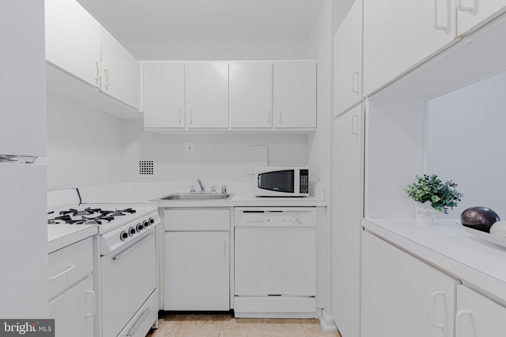 950 25th Street Northwest, Unit 327N Washington, DC 20037 - Photo 5 of 29 a kitchen with white cabinets and appliances