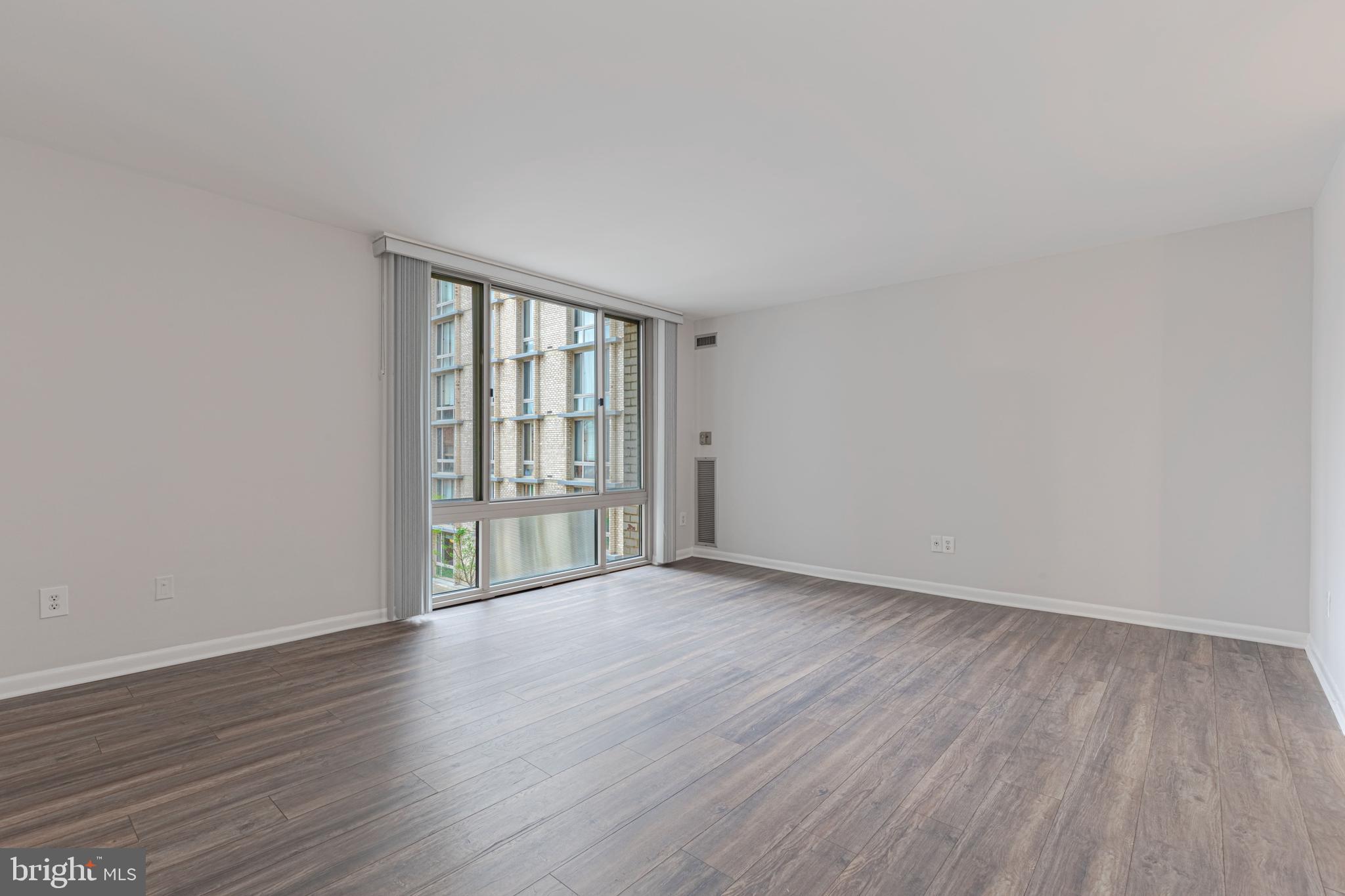 950 25th Street Northwest, Unit 327N Washington, DC 20037 - Photo 9 of 29 a view of an empty room with wooden floor and a window